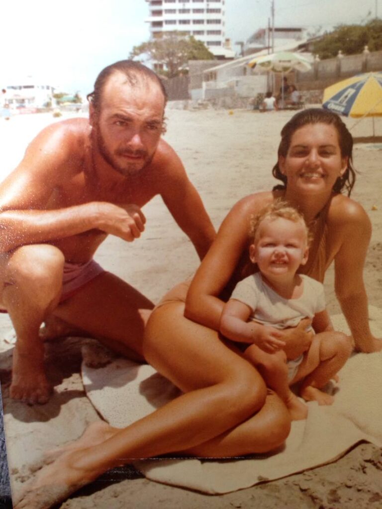 Raul Mendoza, Deborah Medley, and young Melodia relaxing on a beach in Ecuador, a glimpse into the family life and experiences that shaped Melodia's artistic journey.
