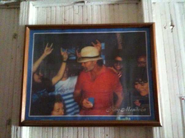 Framed photograph of Raul Mendoza dancing and celebrating with friends, reflecting the vibrant spirit and love of music remembered by his family.