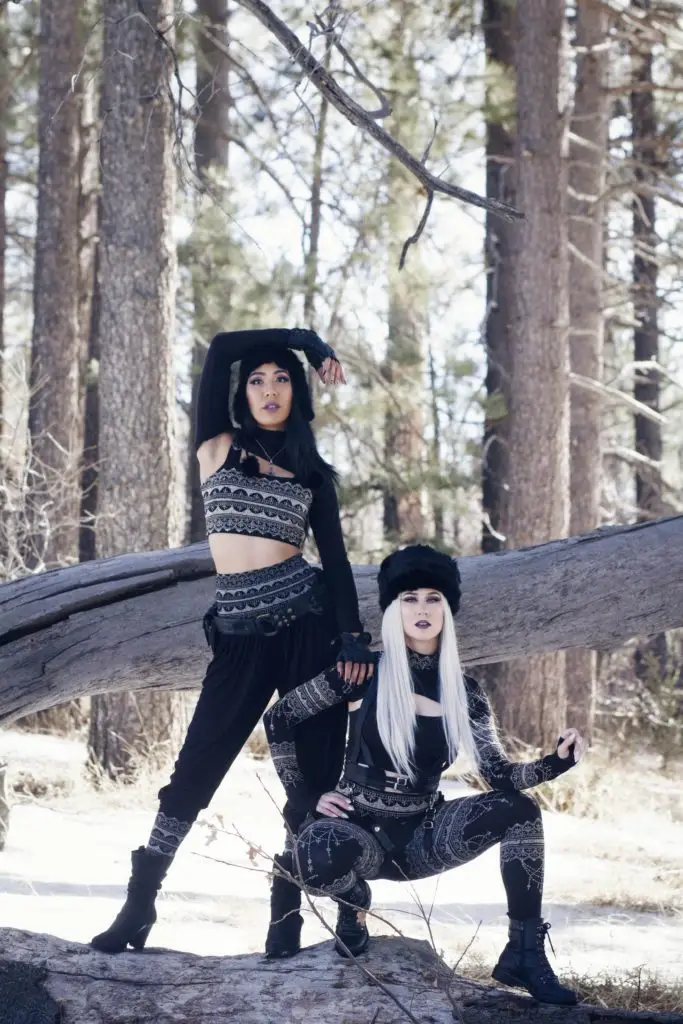 Models wearing Mehndi Collection henna-print leggings and crop top during winter photoshoot in snowy forest setting.