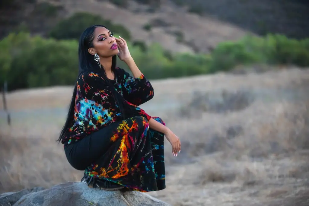 Woman in colorful tie-dye outfit from Melodia Designs' Black Prism Tie-Dye Collection.