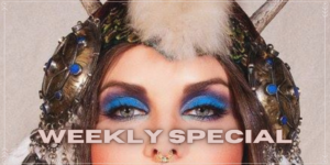 Close-up of a person wearing bold blue eye makeup and an ornate headpiece with feathers and beads, with the text "WEEKLY SPECIAL" across the image.