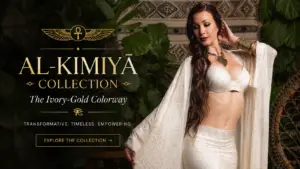 Featured image for the Al-Kīmiyā Collection by Melodia Designs featuring the Ivory-Gold colorway, showcasing a model in flowing Egyptian-inspired ivory fashion with metallic gold detailing, styled in a lush botanical setting with bohemian decor and regal jewelry.