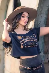 Detail of OUIJA Dede crop top graphic paired with Rustique Moto leggings