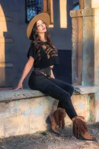 Woman sitting wearing OUIJA Dede crop top and Rustique Moto leggings outfit