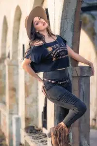Model wearing OUIJA Dede crop top and Rustique Moto leggings posing outdoors