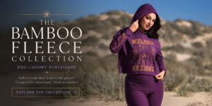 Featured image for the Bamboo Fleece Collection featuring a model in plum bamboo fleece athleisure standing in sunlit desert dunes, styled in eco-luxury activewear with soft neutral tones and elevated bohemian minimalism.