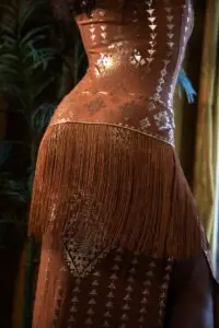 Back view of the Karnak Shimmy sash in copper, showing drape, movement, and metallic fabric detail.