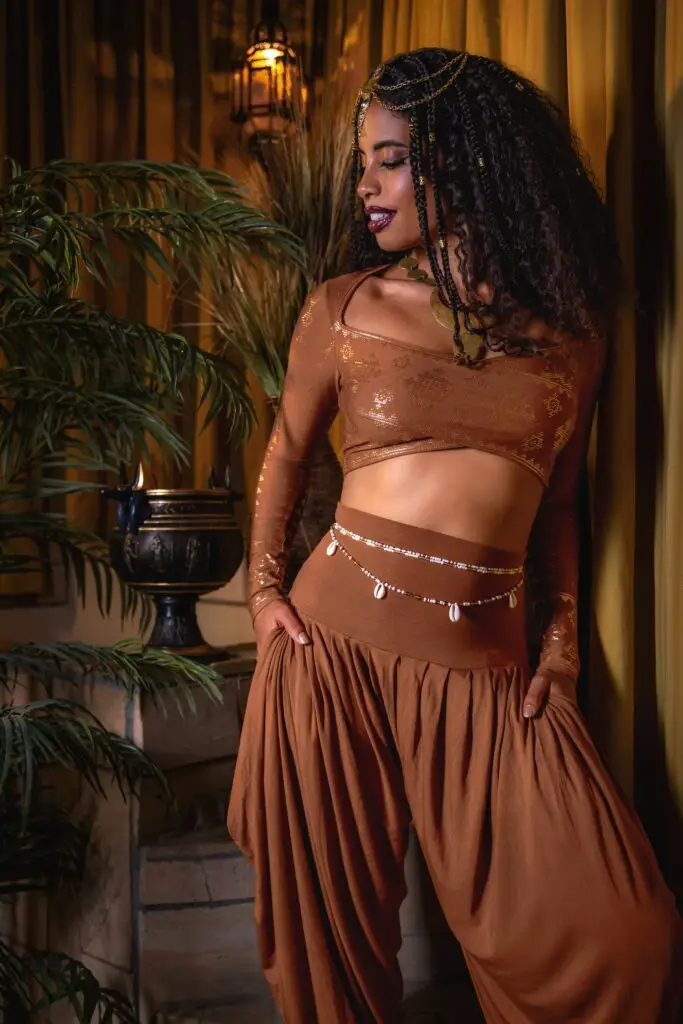 Copper Karnak gown glowing in warm light — fluid movement meets dance-floor glamour.