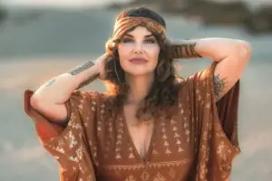 Woman wearing karnak beautyband contessa caftan copper in desert landscape