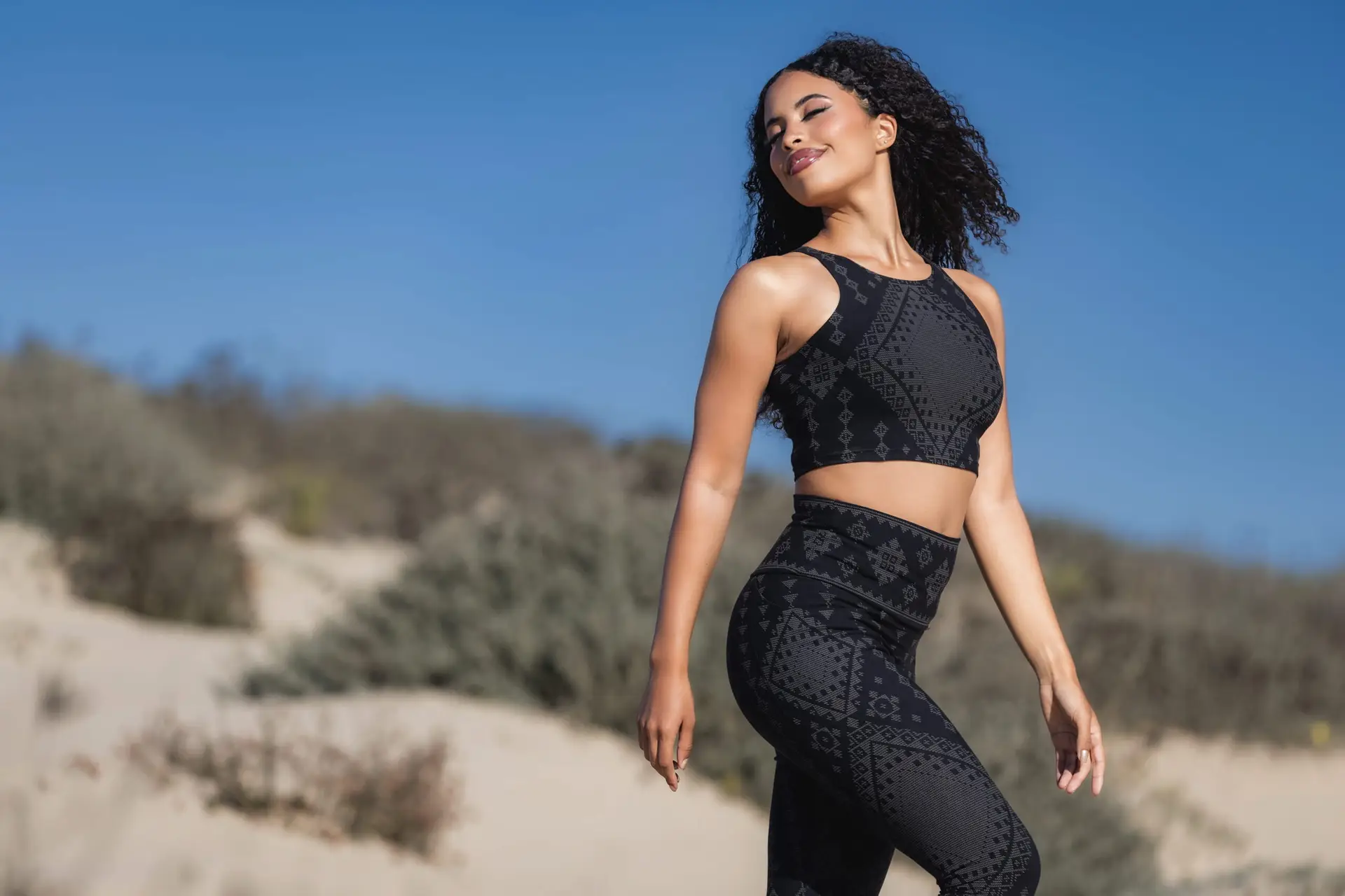 black sacred geometry yoga set from the Karnak Shadow Collection worn on sand dunes