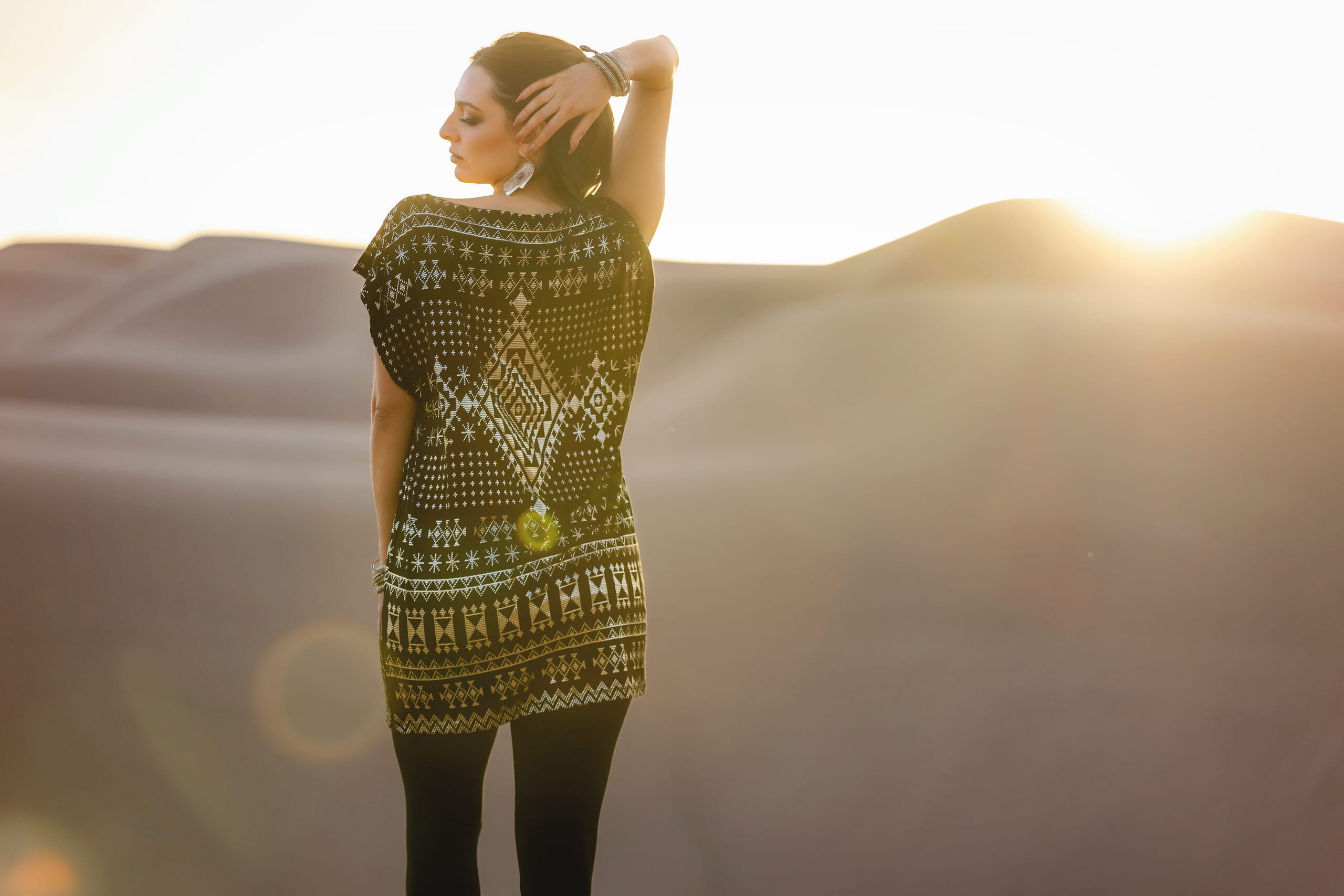 model wearing gold faux assuit dress at sunset overlooking desert mountains