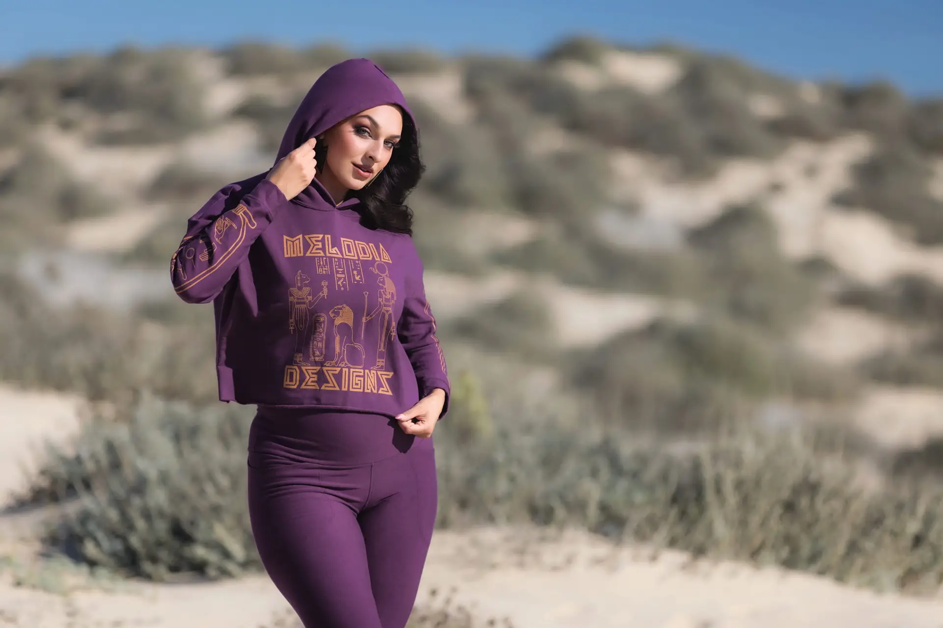 purple bamboo fleece cropped hoodie and leggings athleisure set worn on sand dunes featured in Melodia Designs loyalty program.