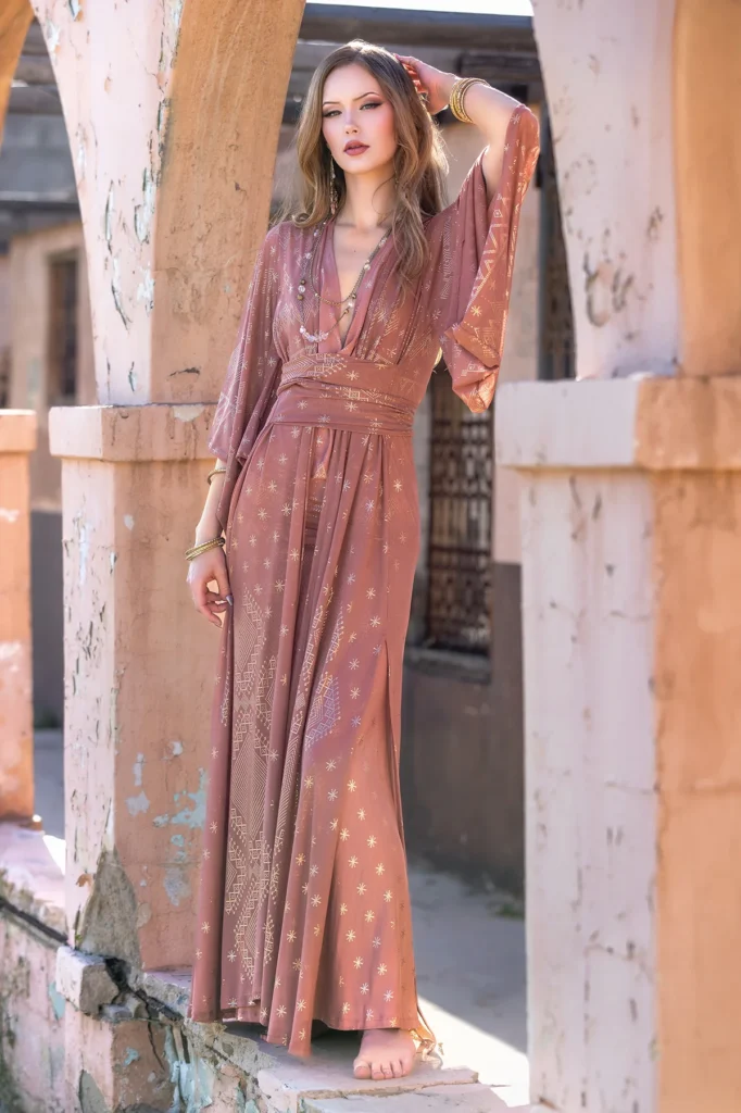 Model wearing Dendera Collection desert rose wrap dress with flowing sleeves and sacred geometry pattern