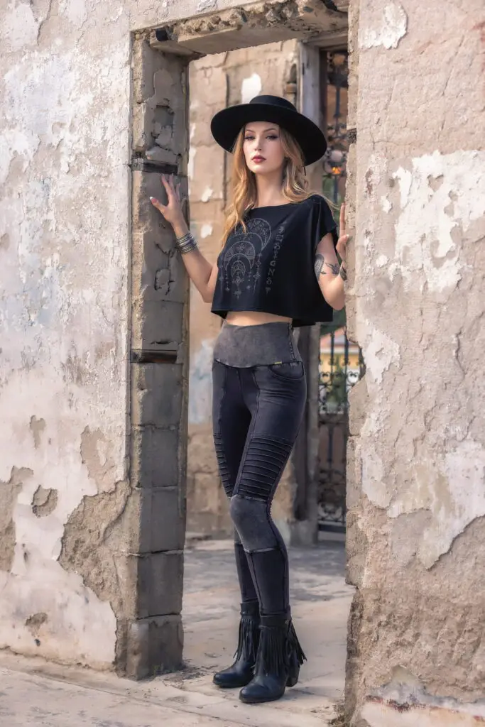 Full-length model portrait featuring the Desert Oracle & River Rock collection against a rustic desert doorway, highlighting earthy textures, sculptural silhouettes, and effortless movement.