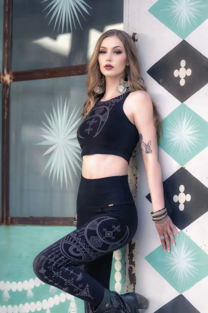 Model wearing the Desert Oracle & River Rock collection beside a colorful geometric mural, showcasing bold pattern, artistic expression, and desert-inspired slow fashion.
